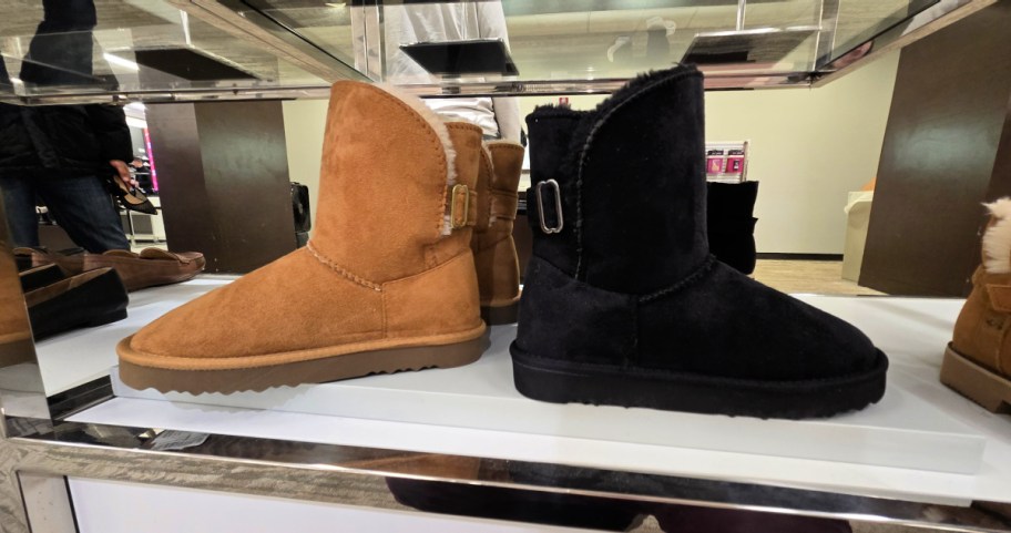 two pairs of fur lined boots on a display