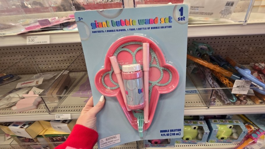 womans hand holding a giant bubble wand set