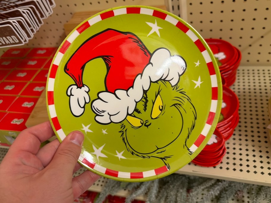 hand holding green grinch plate 