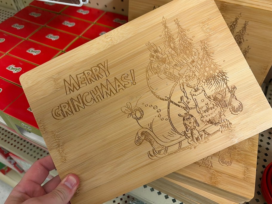 hand holding grinch bamboo cutting board