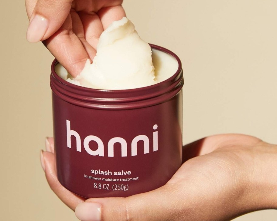 hand scooping hanni lotion out of container