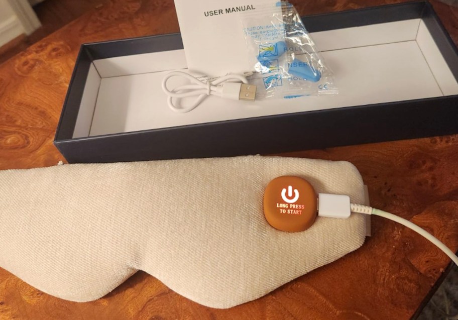 beige heated eye mask with box on wood table