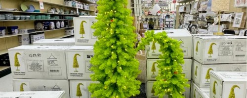 two Grinch trees on display in a store
