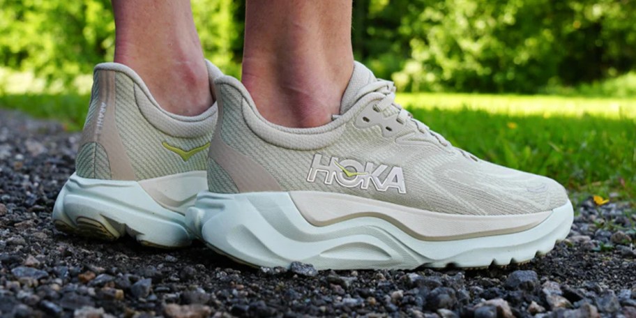 person wearing light green hoka shoes