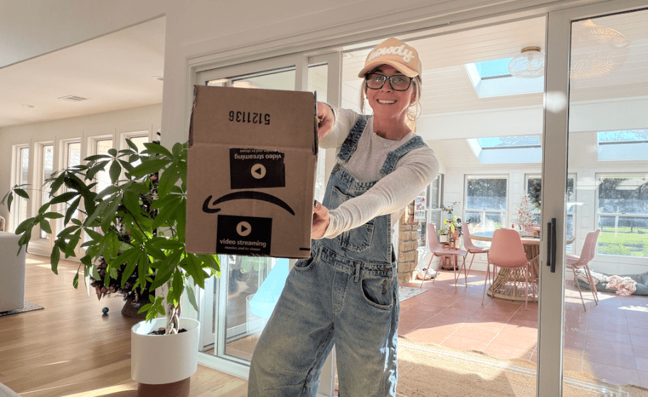 woman holding up amazon boxes