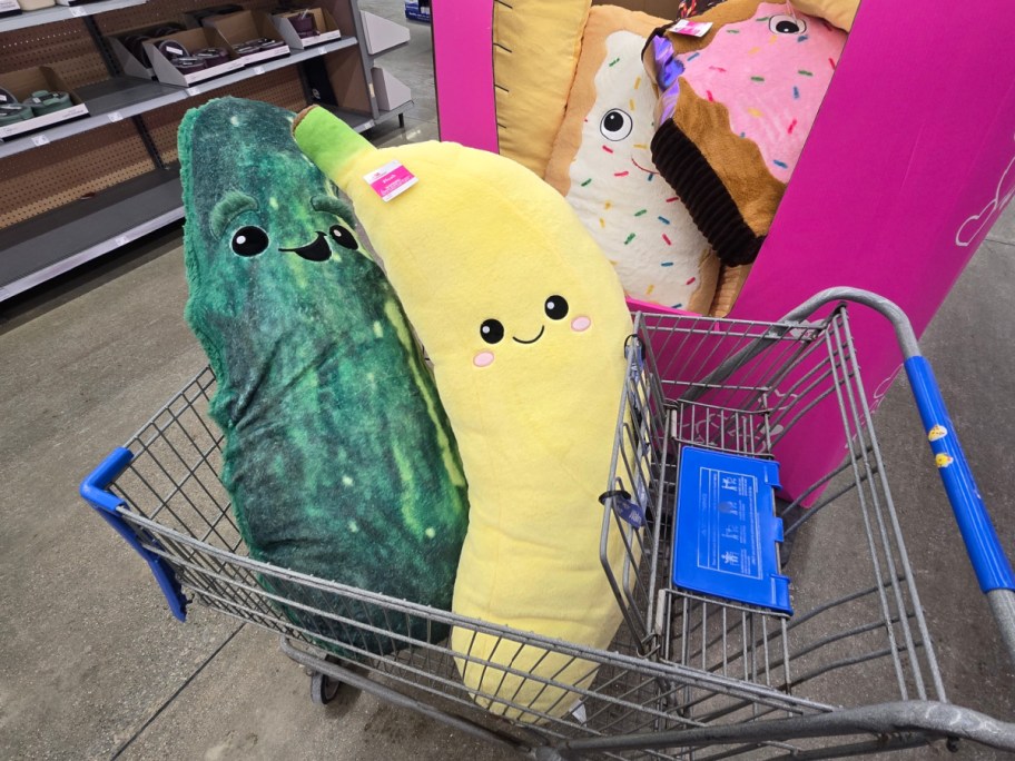 A pickle jumbo plush and a banana jumbo plush in a cart at Walmart.