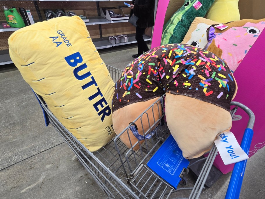 A butter jumbo plush and a fortune cookie jumbo plush in a cart at Walmart.
