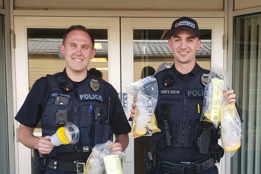 police in front of doorway holding life saving choking devices