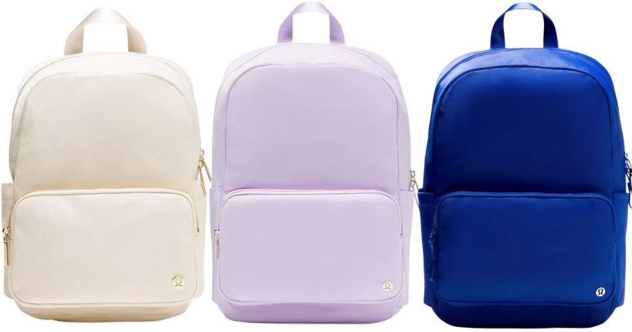 3 backpacks in cream, purple, and blue