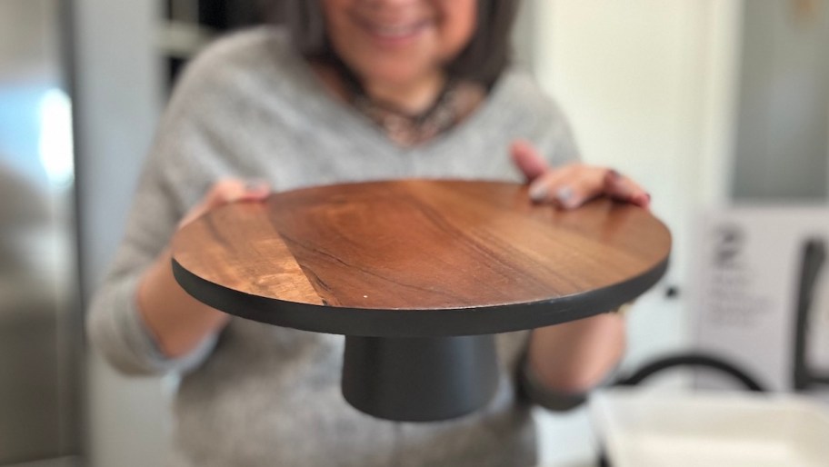 woman holding wood cake stand 