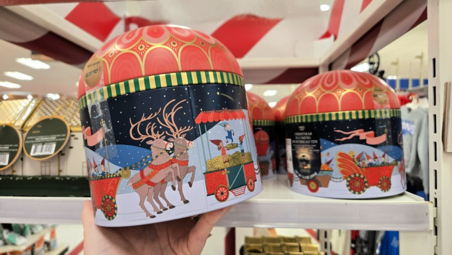 hand holding up a light up cookie projector tin in a store aisle