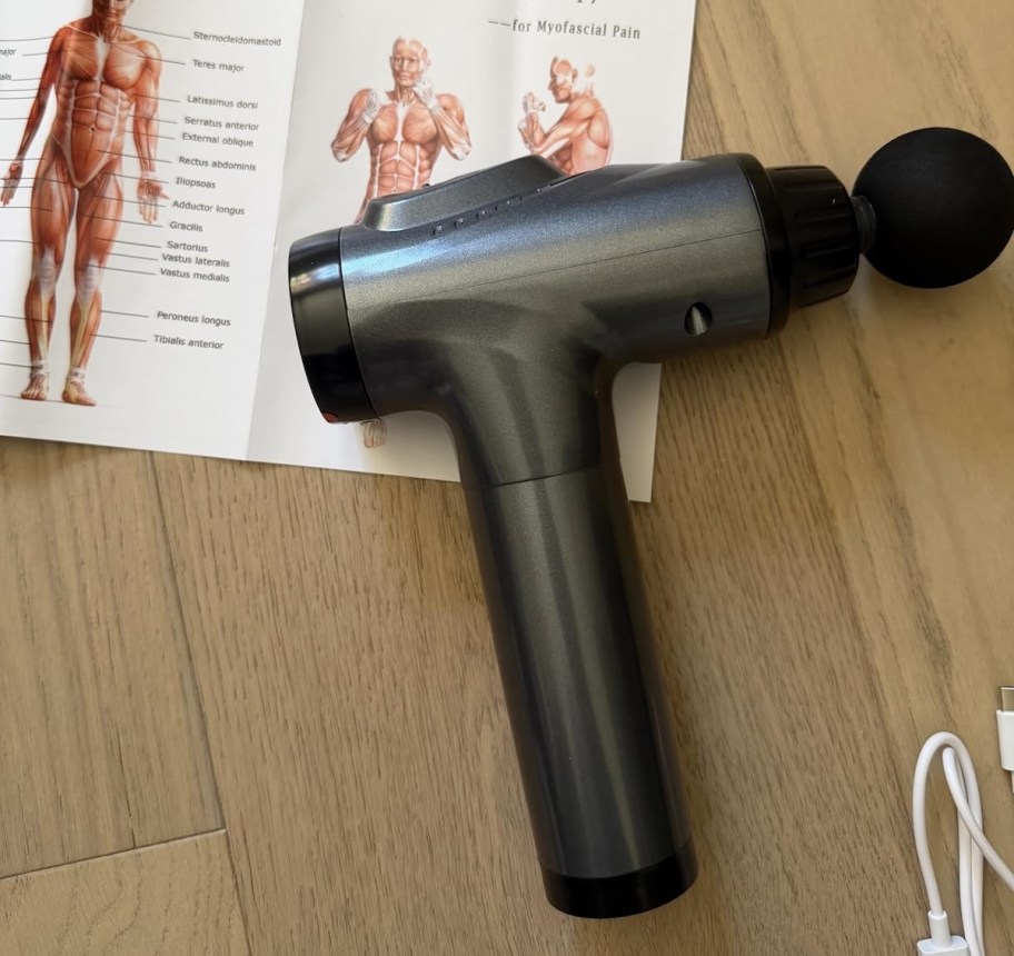 gray massage gun on wood floor