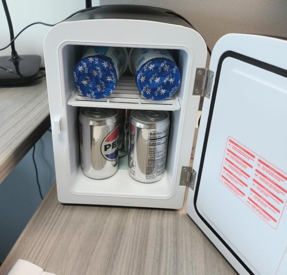 open mini fridge with pepsi