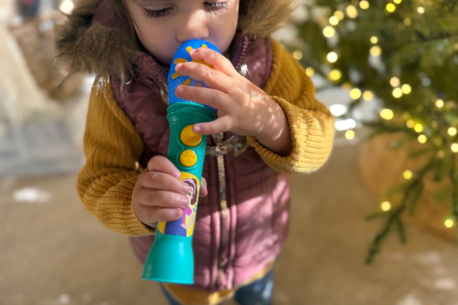toddler holding a ms rachel microphone