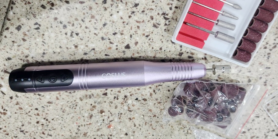 purple nail drill and accessories on counter 