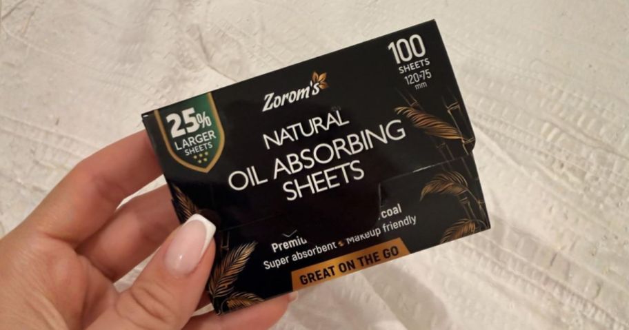 hand holding natural oil absorbing sheet pack