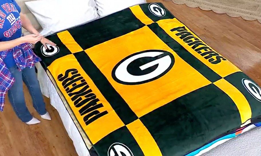 yellow and green packers blanket on bed 