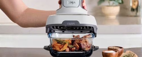 person holding Ninja Crispi 3-in-1 Glass Air Fryer on counter