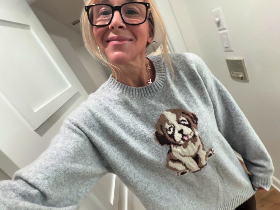 smiling woman wearing a dog print sweater