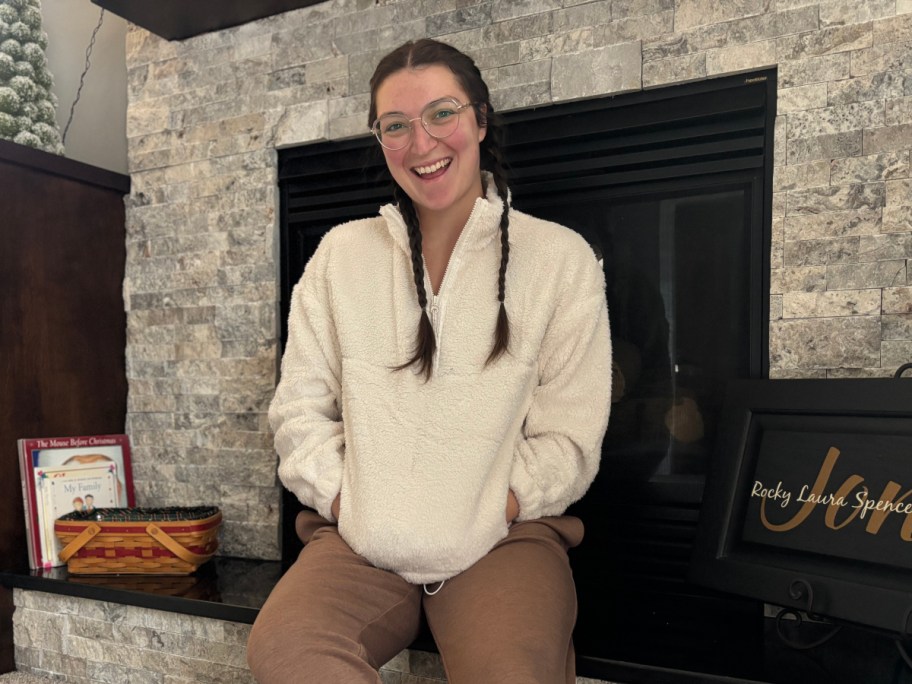 woman in white fleece sitting on mantel