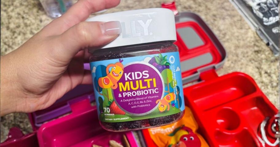 hand holding OLLY Kids Multivitamin & Probiotic Gummies 70-Count above lunch box