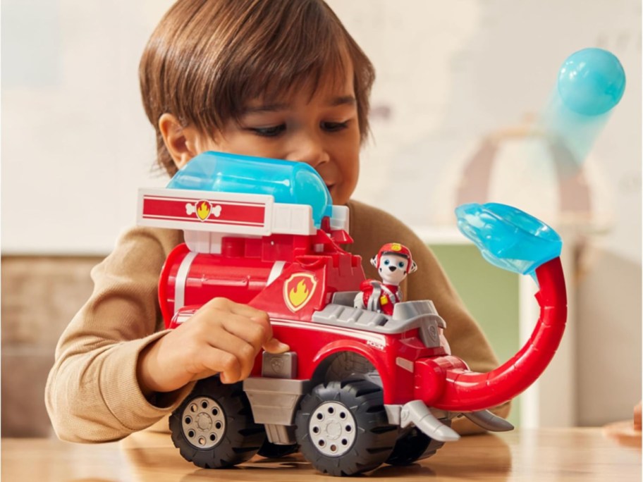 boy playing with a paw patrol fire truck