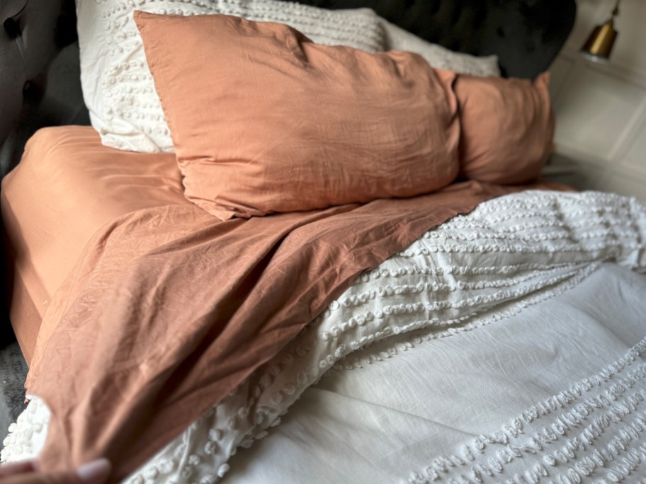 orange sheet and pillow cases on bed