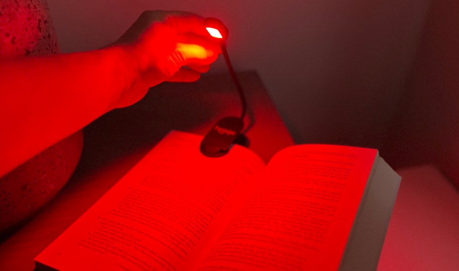 hand holding top of red light book light