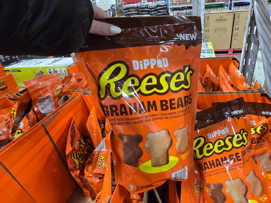 a womans hand holding a bag of dipped reeses bears