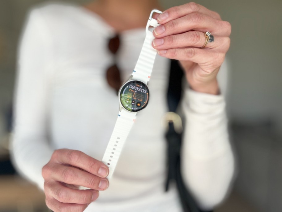 woman holding a samsung smart watch by both ends, showing the face