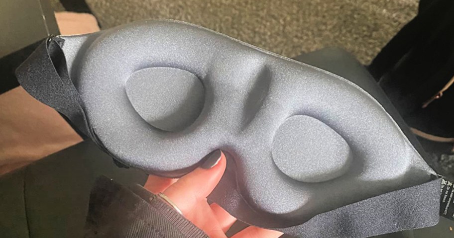 woman holding a gray sleep mask