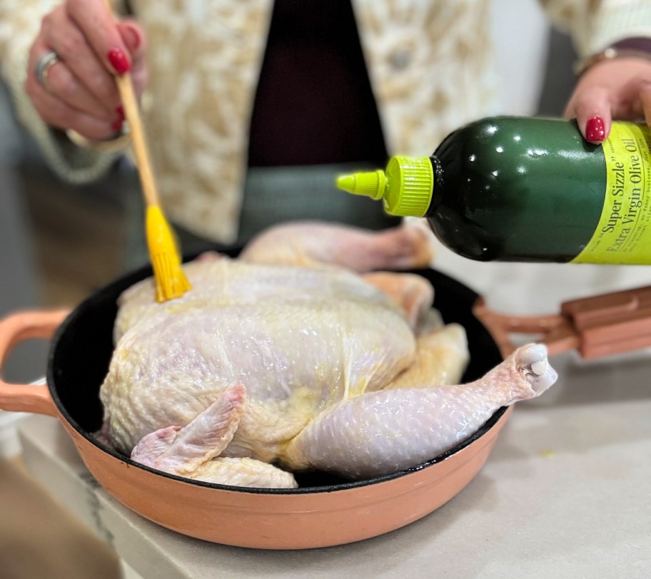 spreading olive oil on chicken