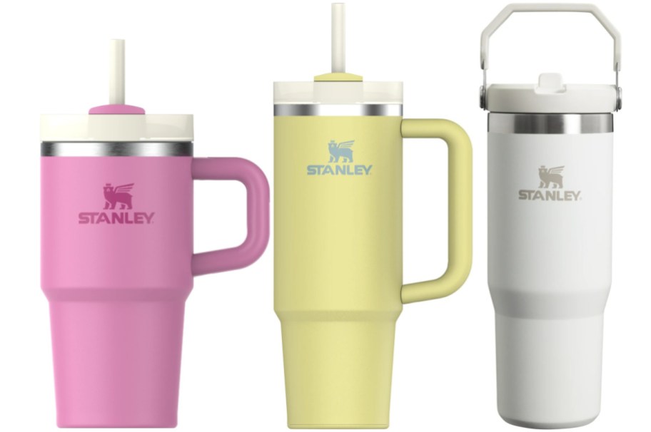 Three Stanley water bottles in pink, yellow and white.