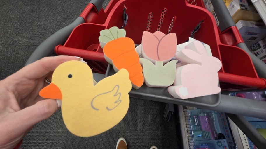 womans hand holding a wooden figural shape of a ducky