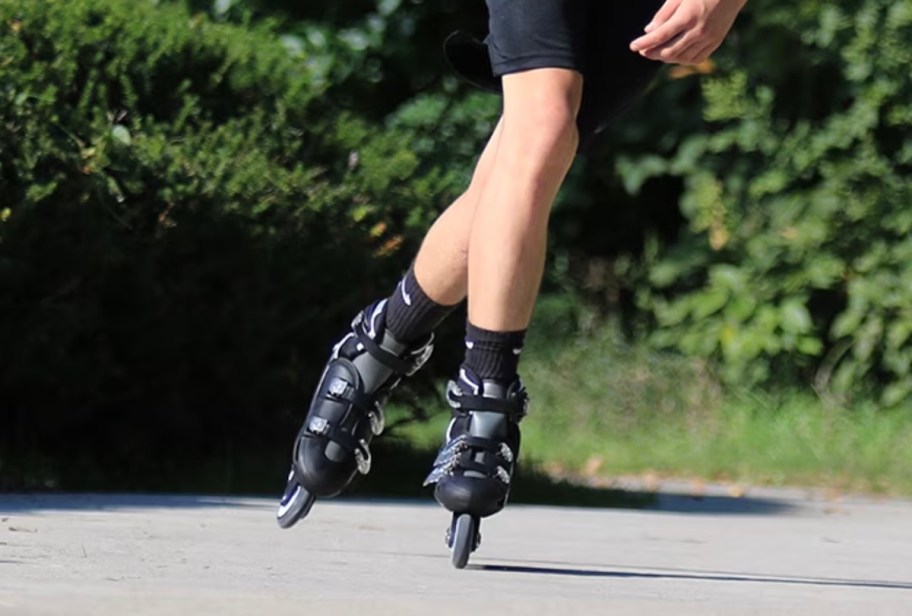 close up of man wearing black roller skates 