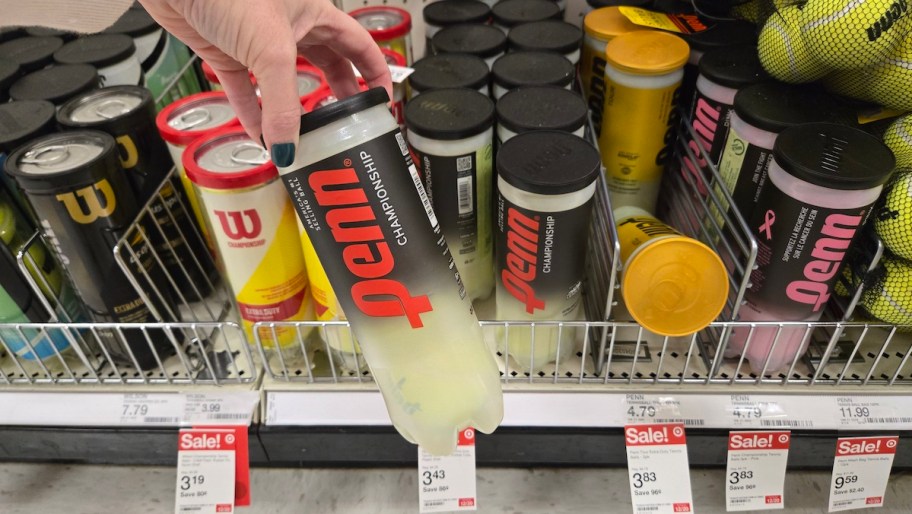 hand holding a pack of tennis balls