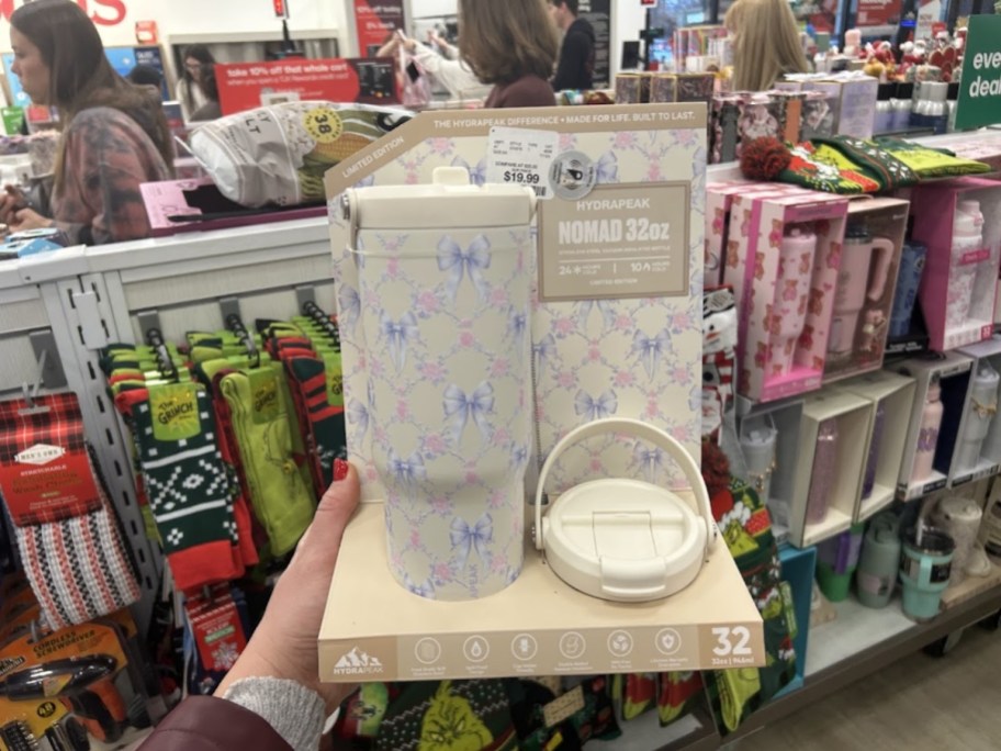 hand holding a tumbler with extra lid in a box in a store