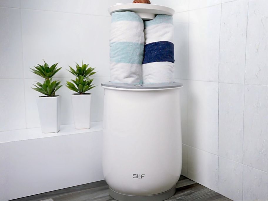 towel warmer with towels in it in bathroom