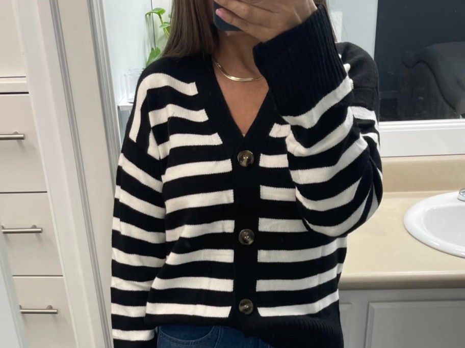 woman in striped cardigan taking selfie