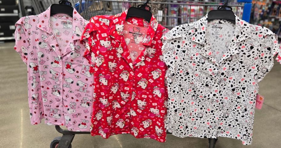 a snoopy, hello kitty, and 101 dalmations valentines day pajamas hanging on cart in store