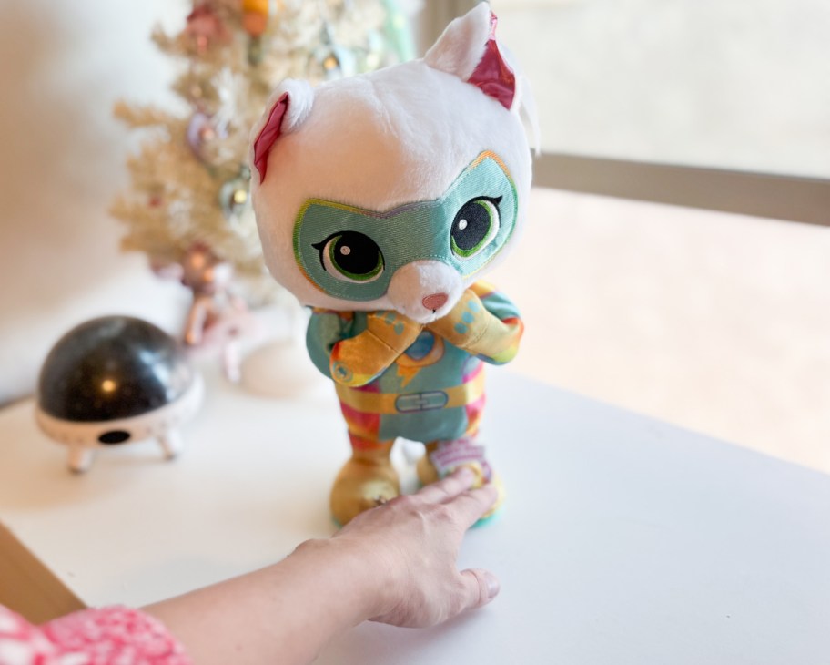 hand pressing white kitty toy button