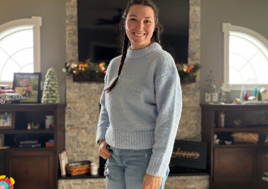 woman standing in front of tv with blue sweater