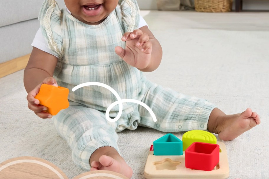 baby holding shape puzzle