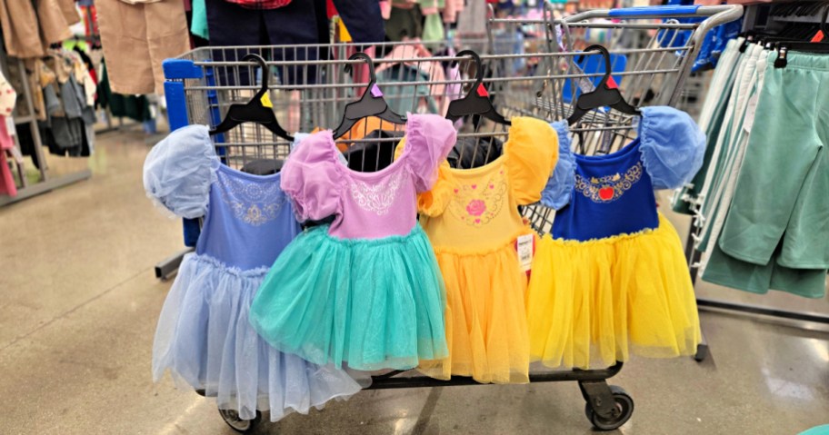 disney princess toddler dresses hanging off the side of a walmart cart in a store