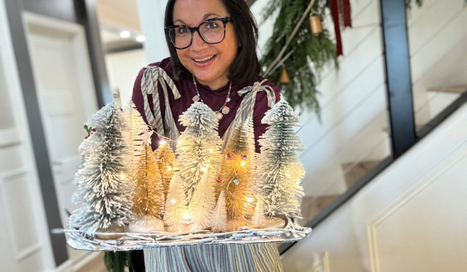 woman holding bottle brush tree centerpiece