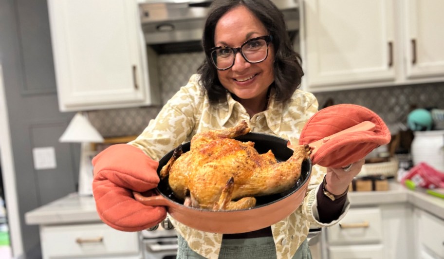 woman holdling a cast iron skillet chicken