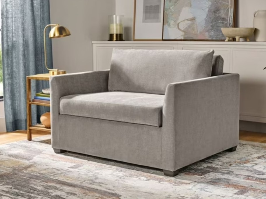 a grey sleeper accent chair in a living room