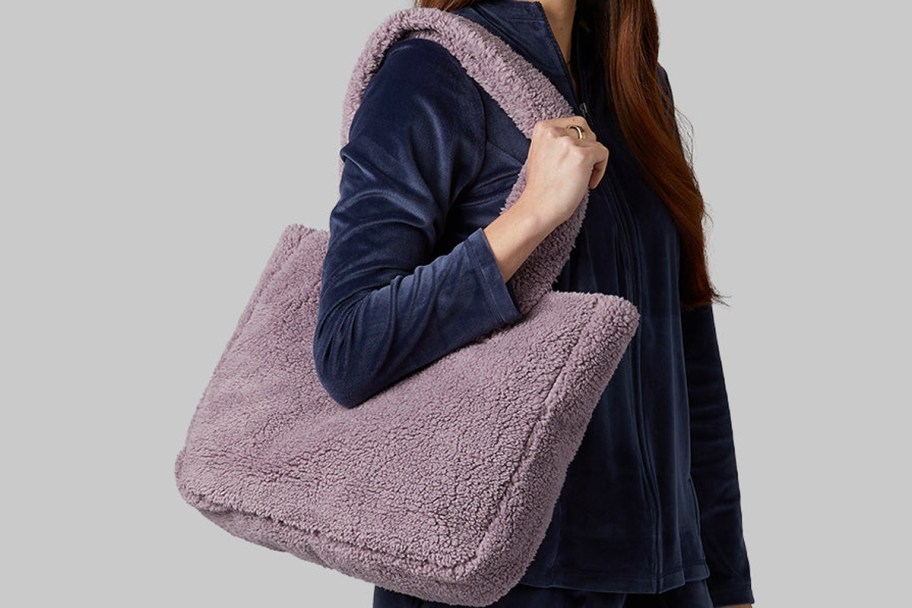 woman carrying purple sherpa tote 