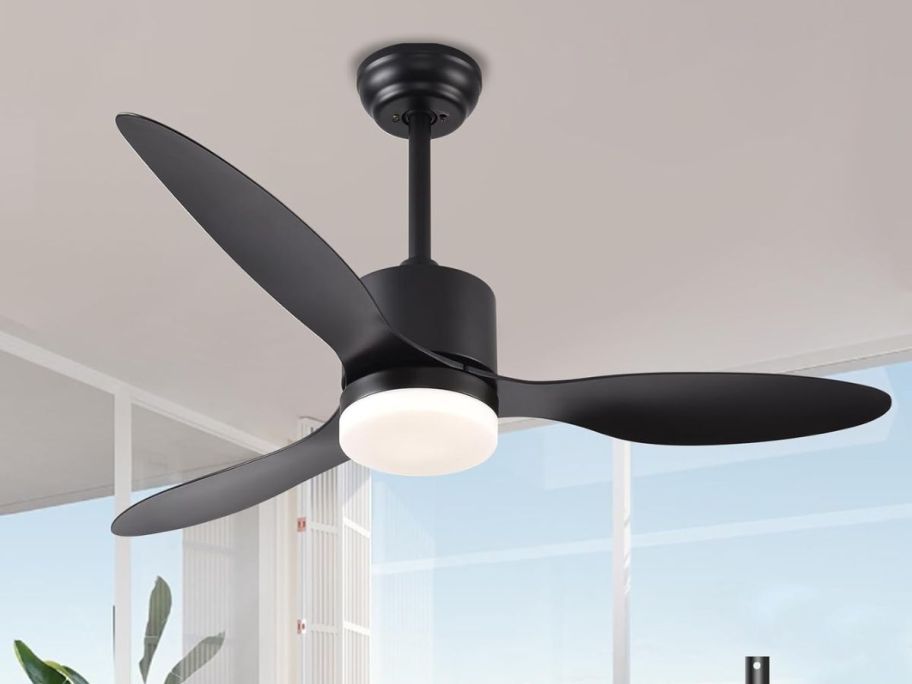A black 3 blade fan with a light 