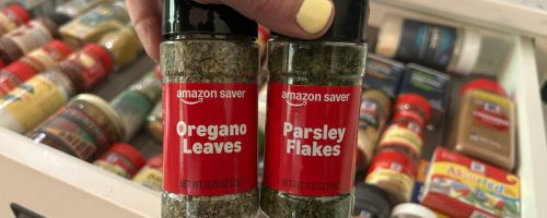 Hand holding two bottles of Amazon Saver Orgenao and Parsely